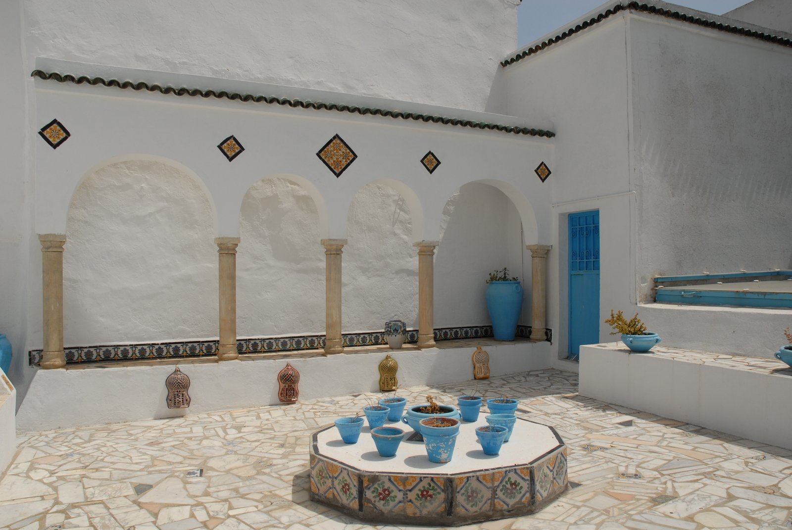 a group of vases and two tables in a courtyard