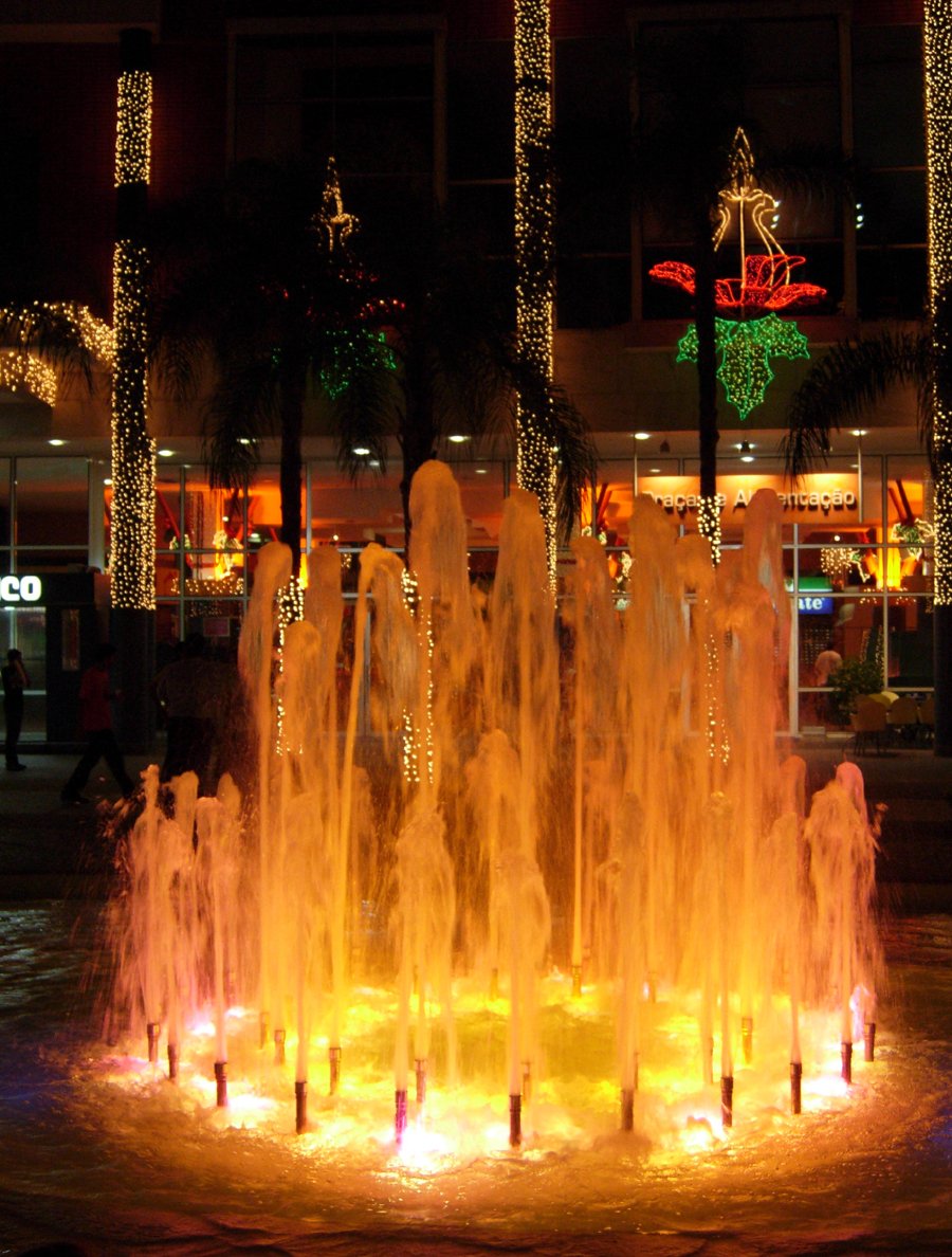an illuminated fountain in front of a building