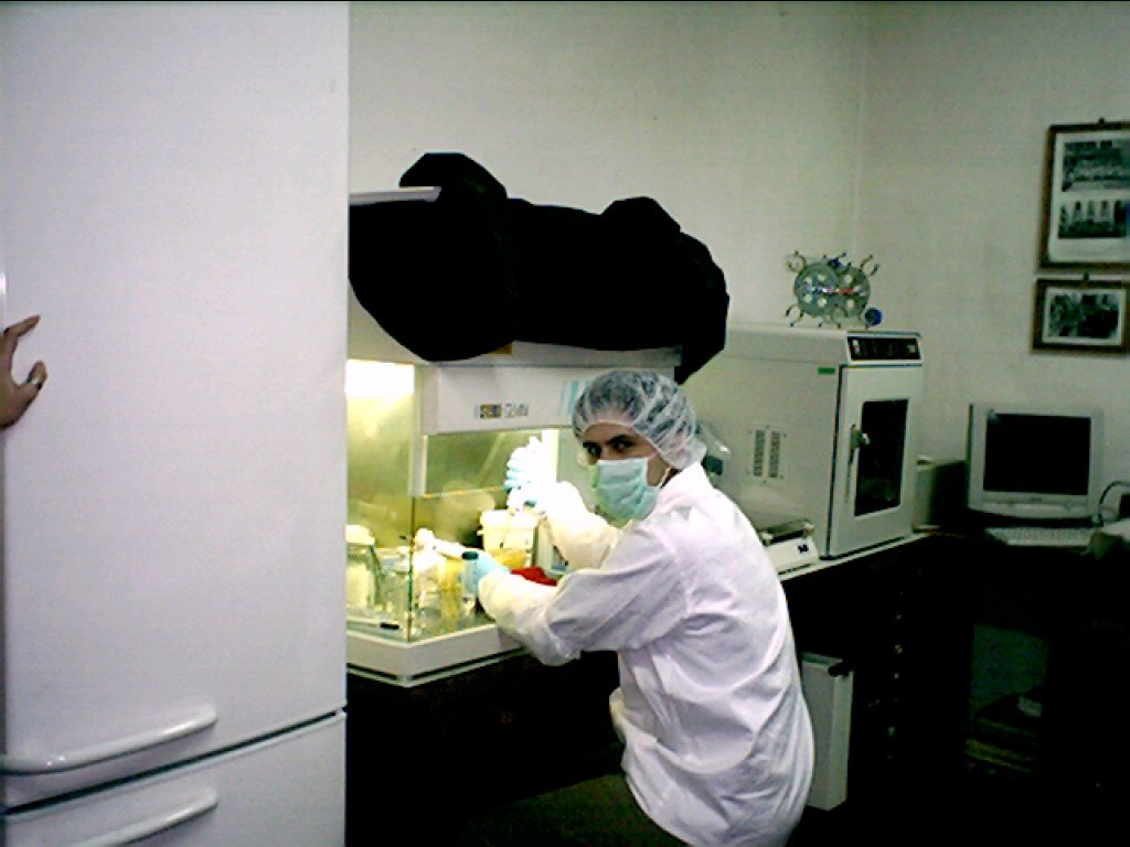 a person in a lab coat with gloves