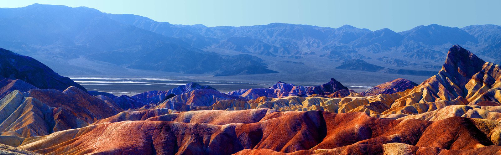 a colorfully colored mountain with a clear blue sky