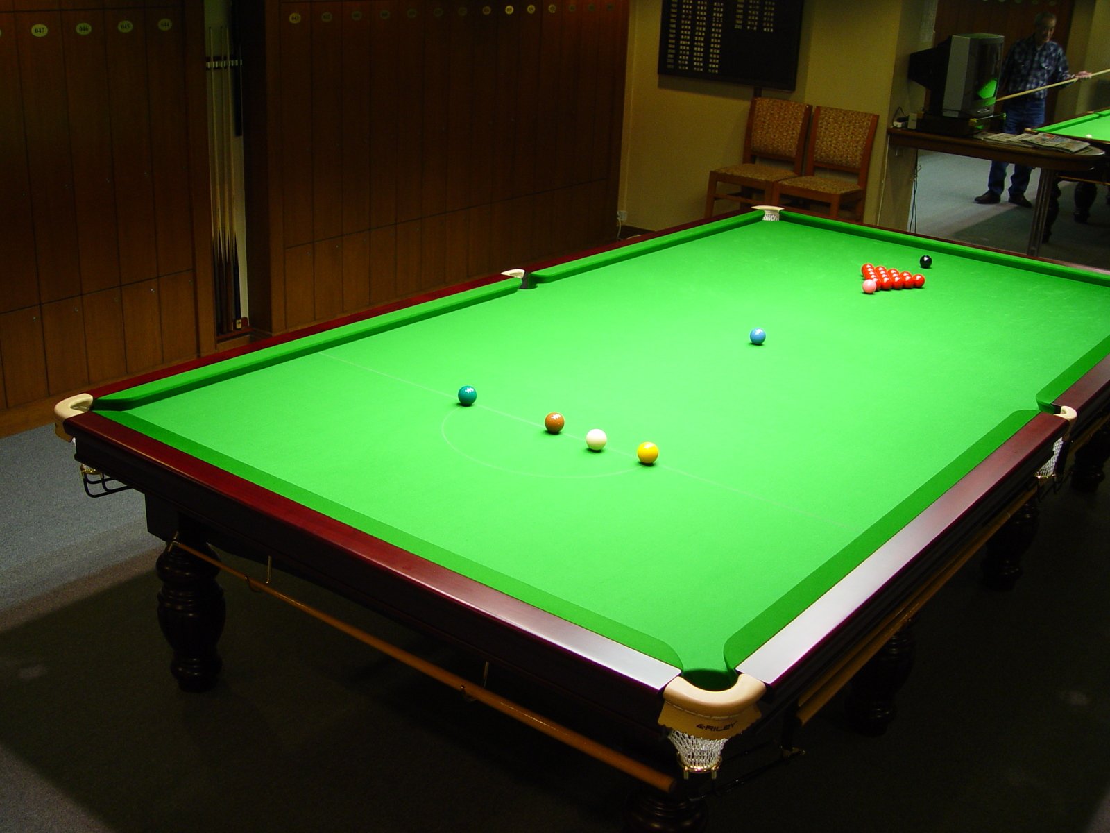 pool table with pool cues laid on top of it