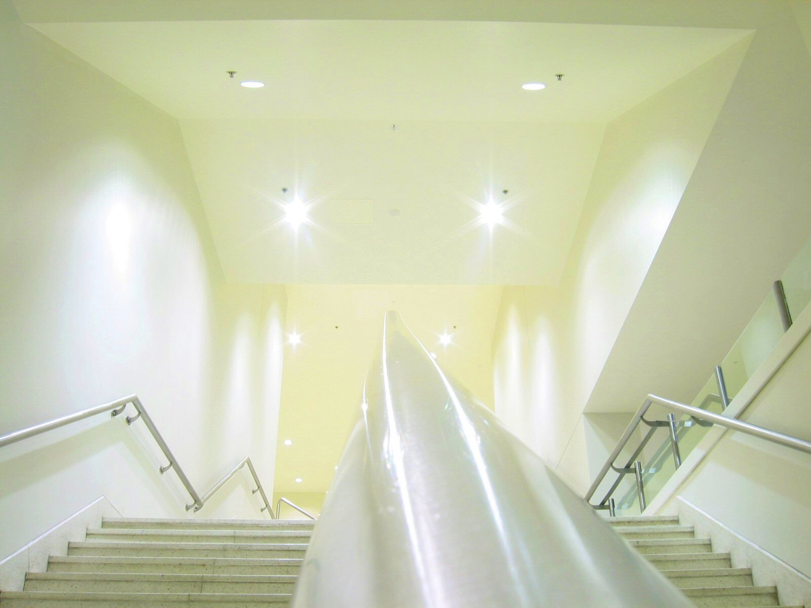 the bottom view of the stairwell with steps and escalator