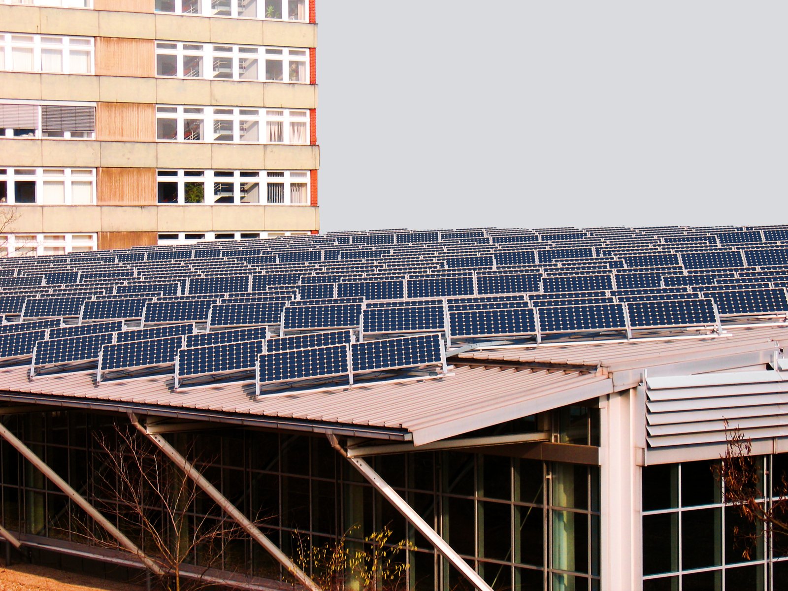 a very long row of solar panels next to a building