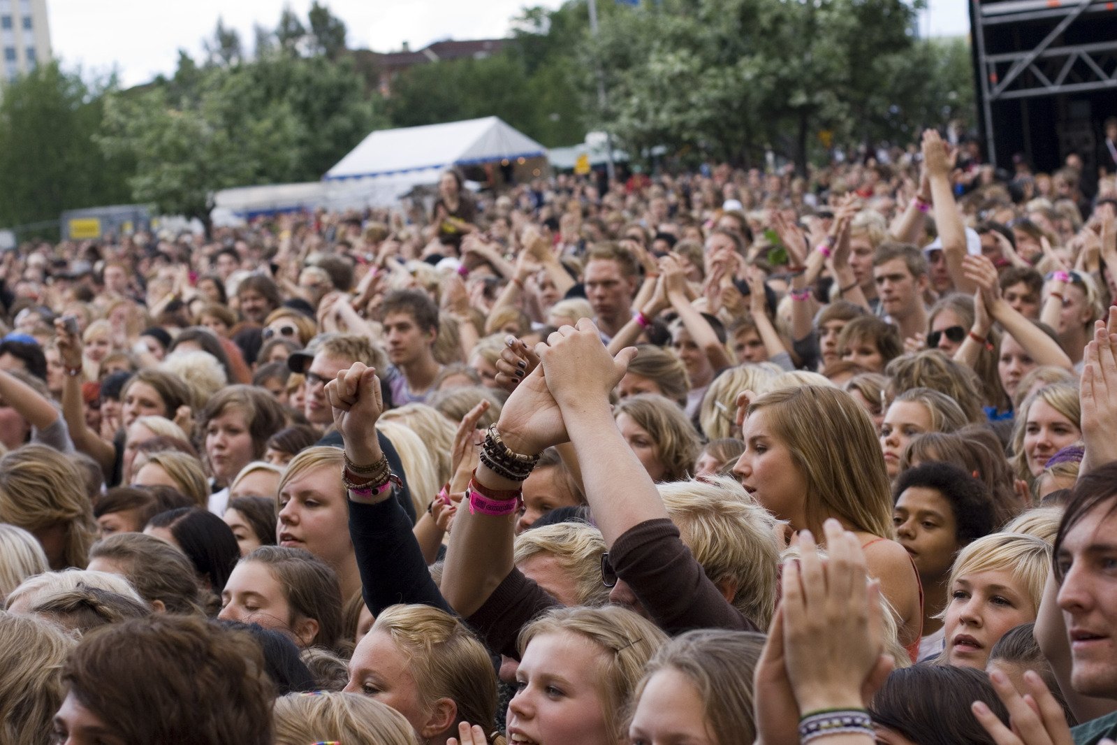 a crowd is standing with their hands in the air