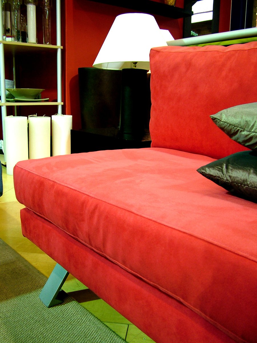 a red couch with a couple black pillows