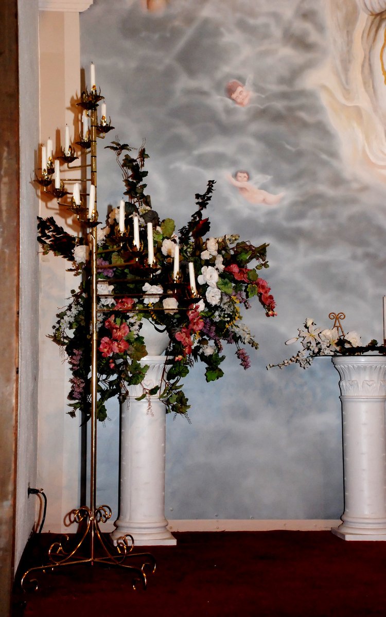 there are candles, flowers and vases on the mantle