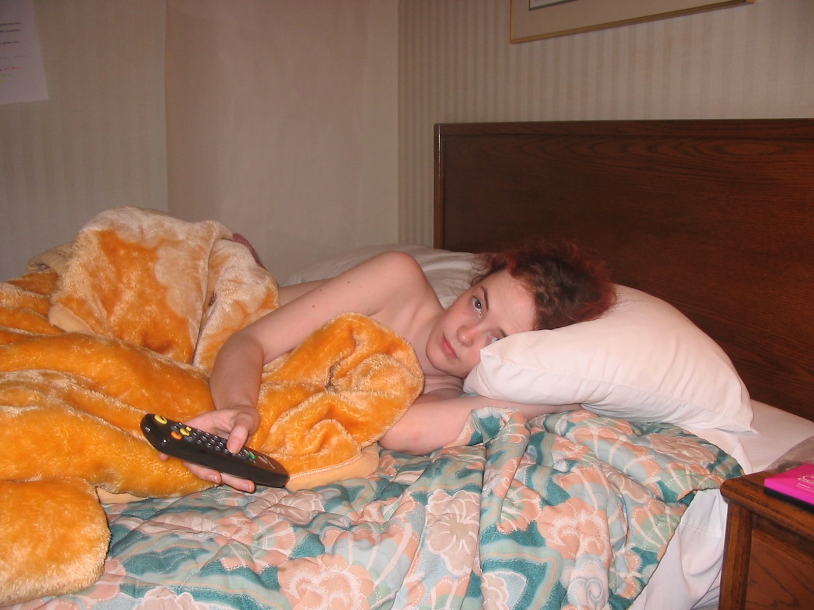 a woman laying in bed holding a teddy bear
