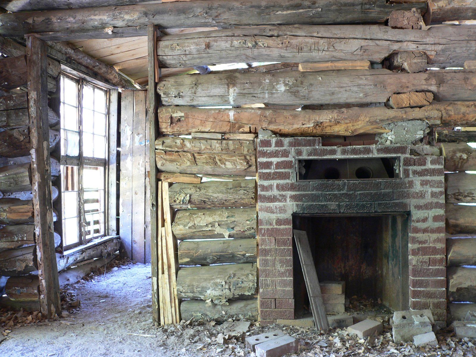a picture of a fireplace in an old log cabin