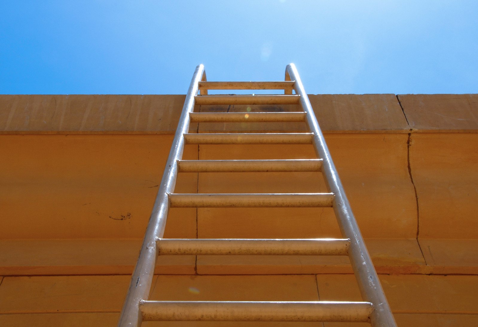 a red fire hydrant and a ladder on a brick building