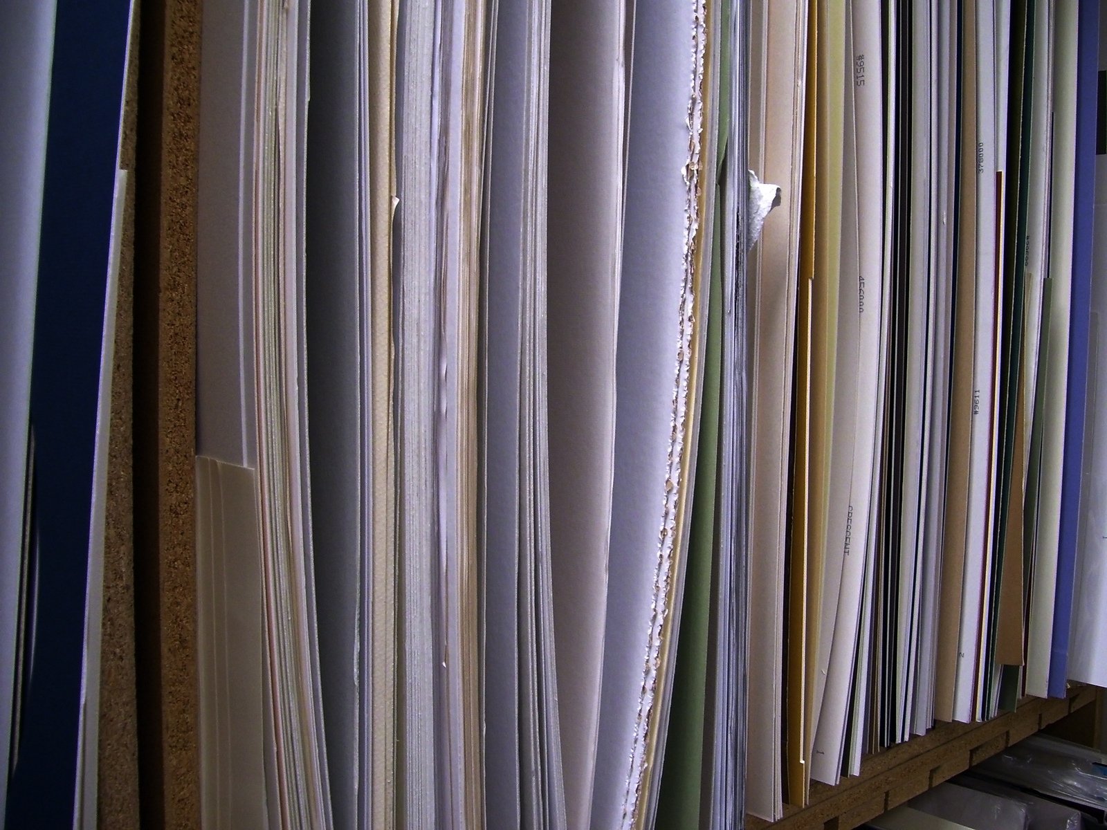 various colored papers and papers hanging on a wooden shelving