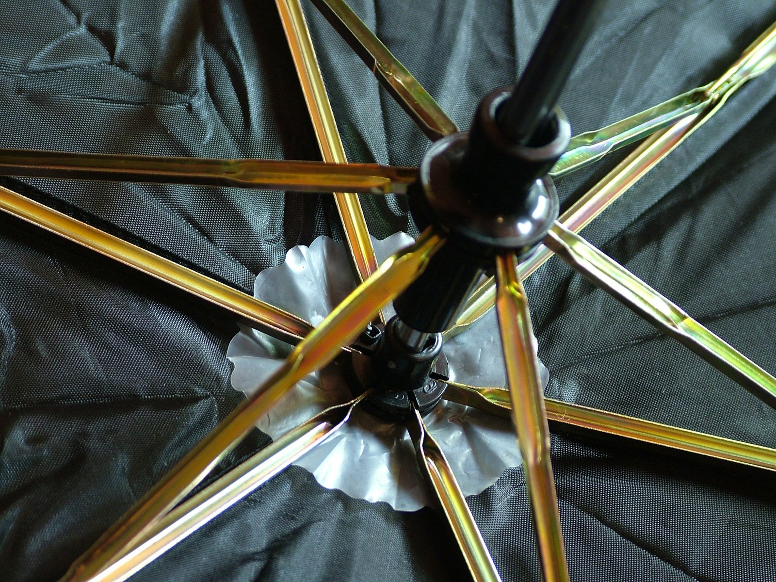 an open umbrella laying on top of a black cover