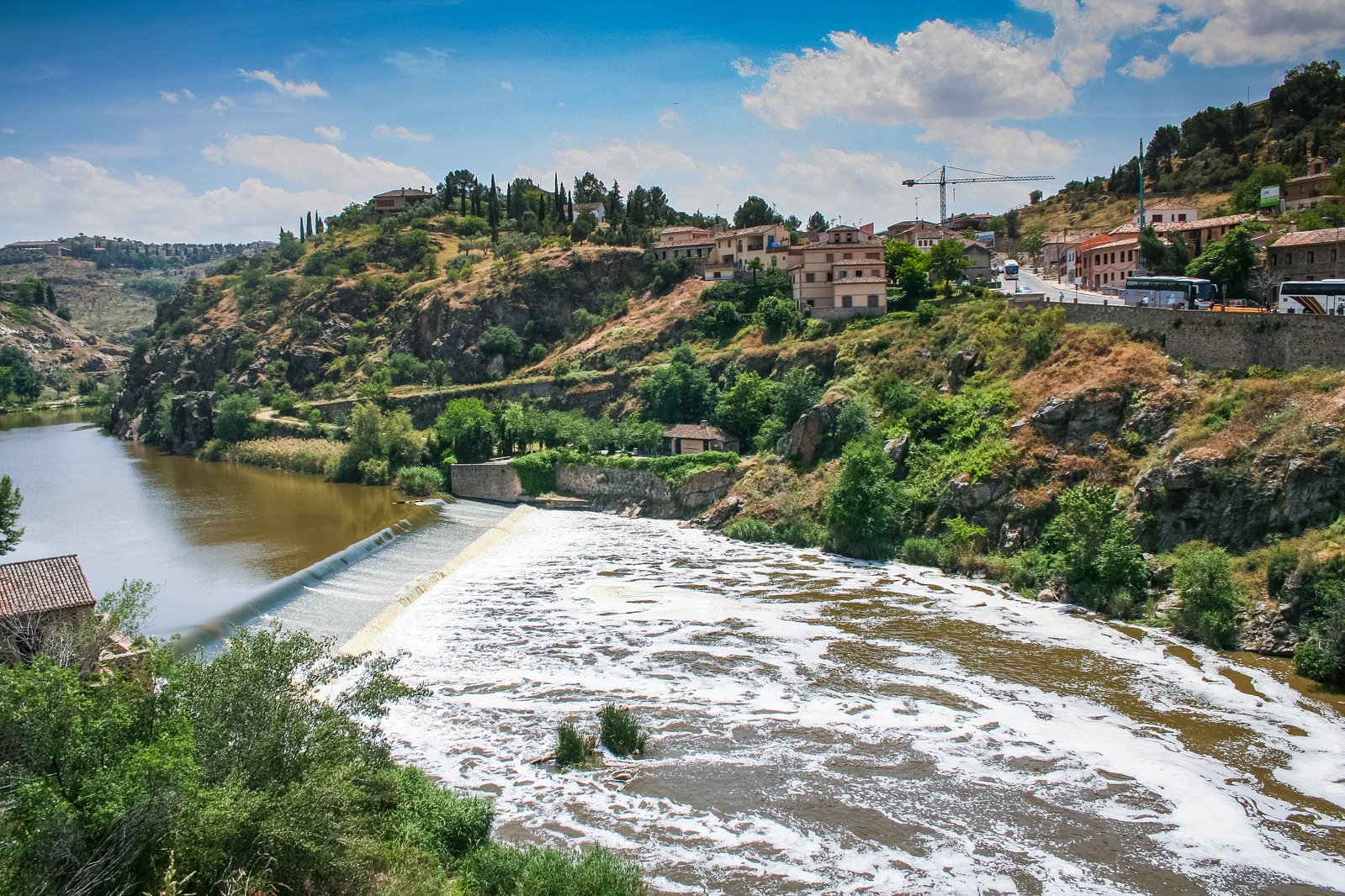 a river running through a lush green hillside filled with water