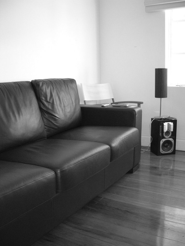 a black couch with a table on it next to a window