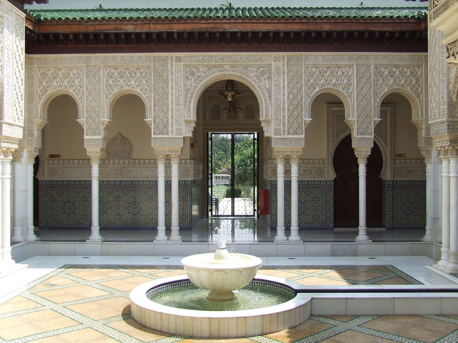 a courtyard in a palace decorated with arches and fountains