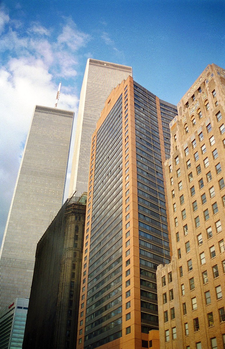 many tall buildings are shown against a blue sky