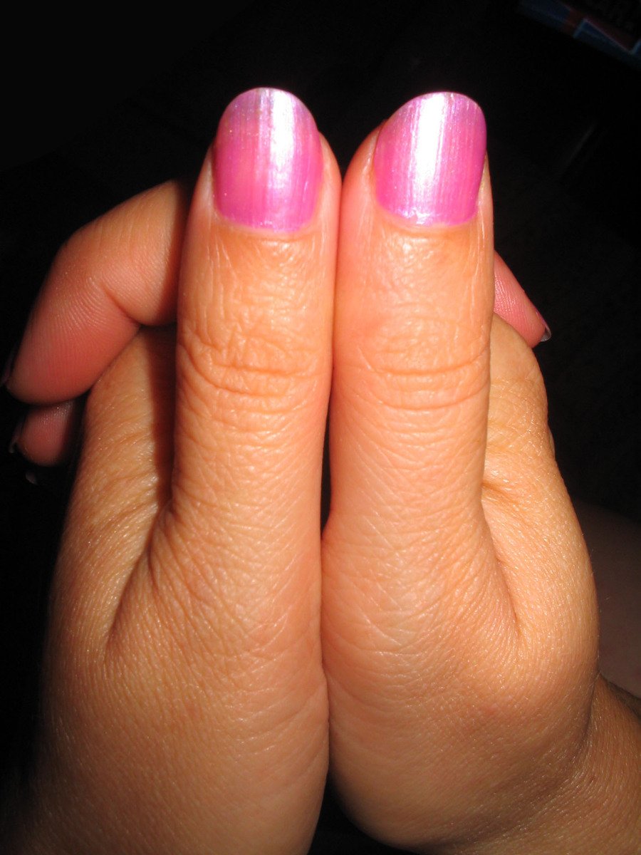 a woman is showing her nails with a pink color