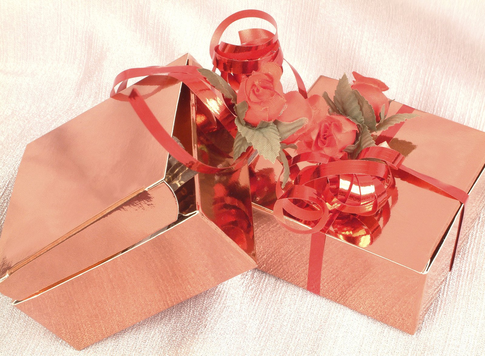 a pink box holding pink roses in a satin bow