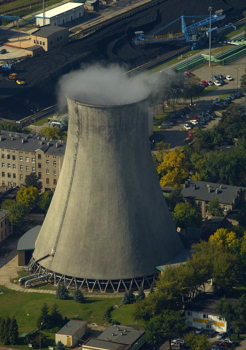 smoke billows from an industrial cooling tower