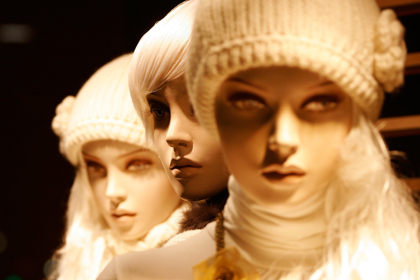 three mannequins dressed up in white knit clothing