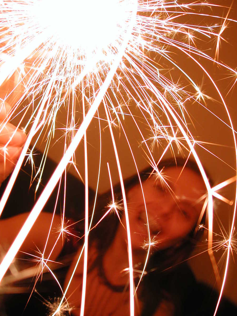 two women taking a selfie while holding sparklers