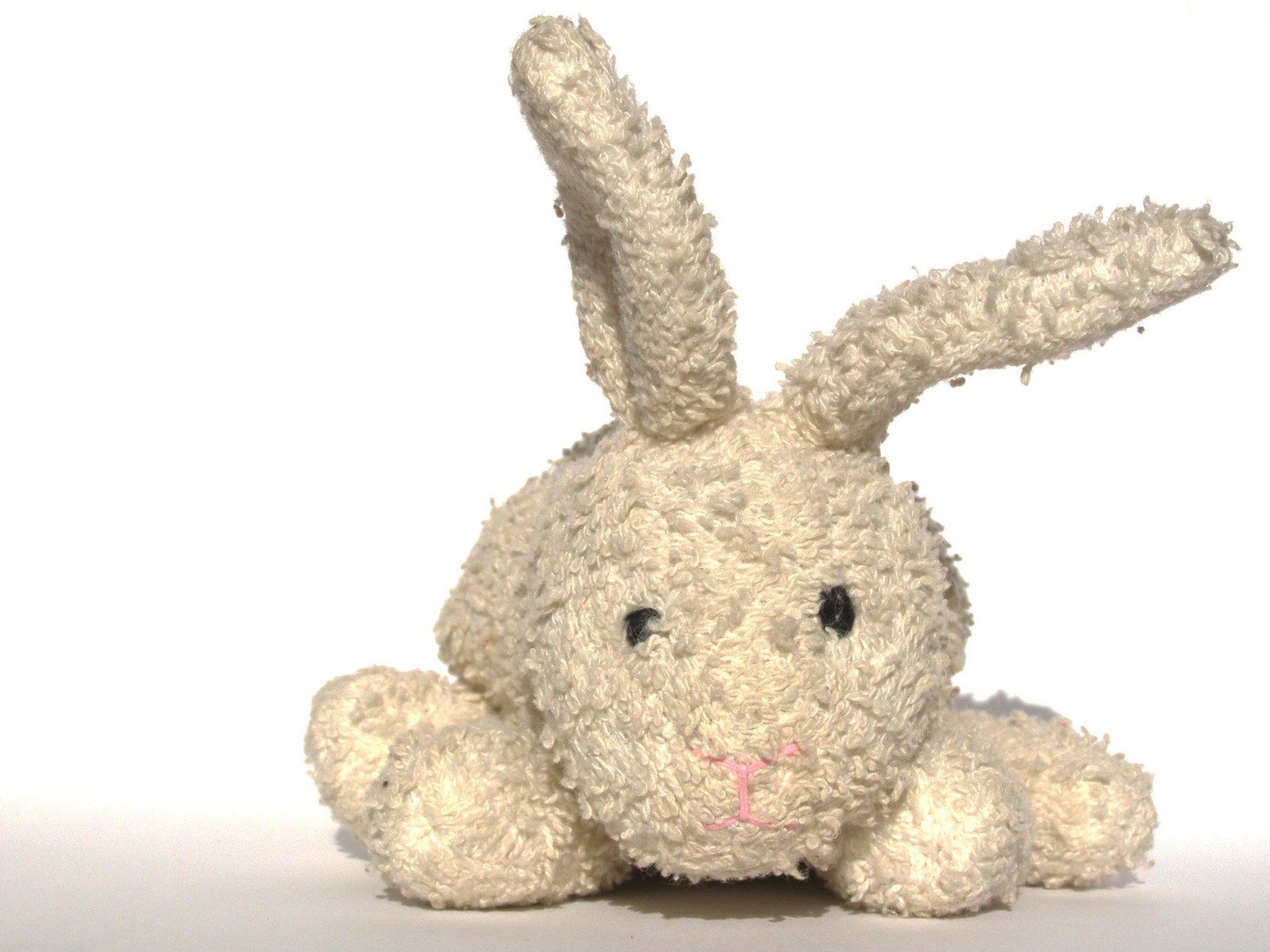 a stuffed animal rabbit sitting on a white surface