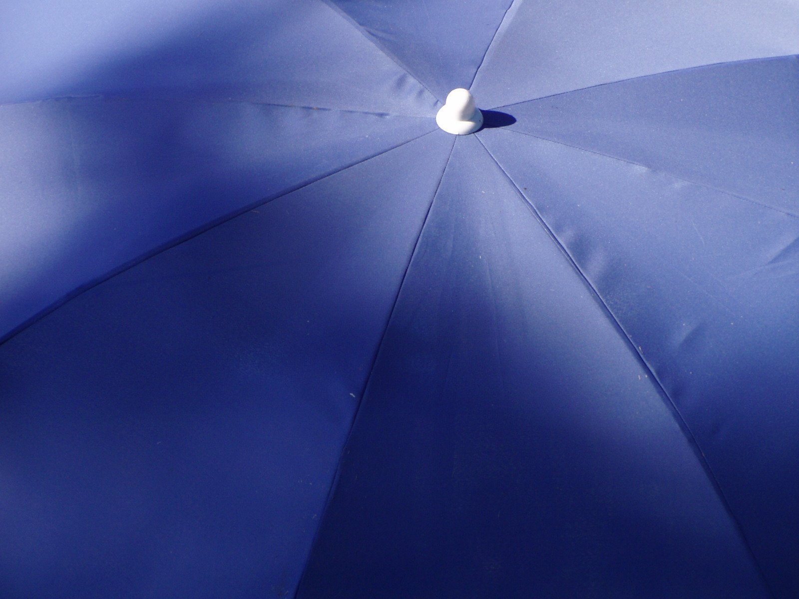 the underside of a blue umbrella with a light on it