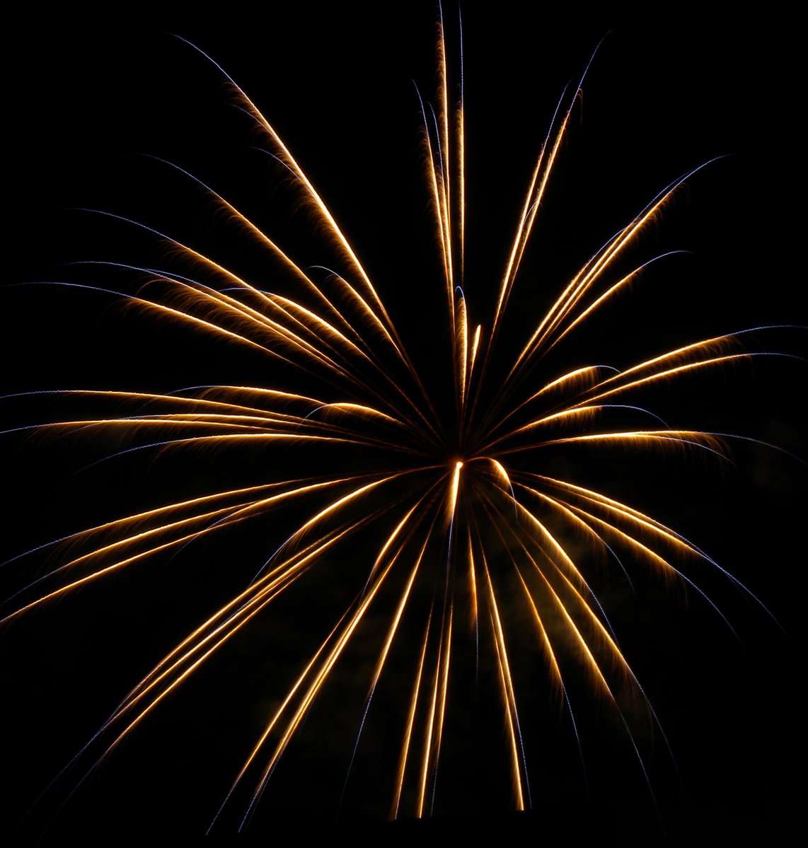 a yellow firework is lit up in the dark sky