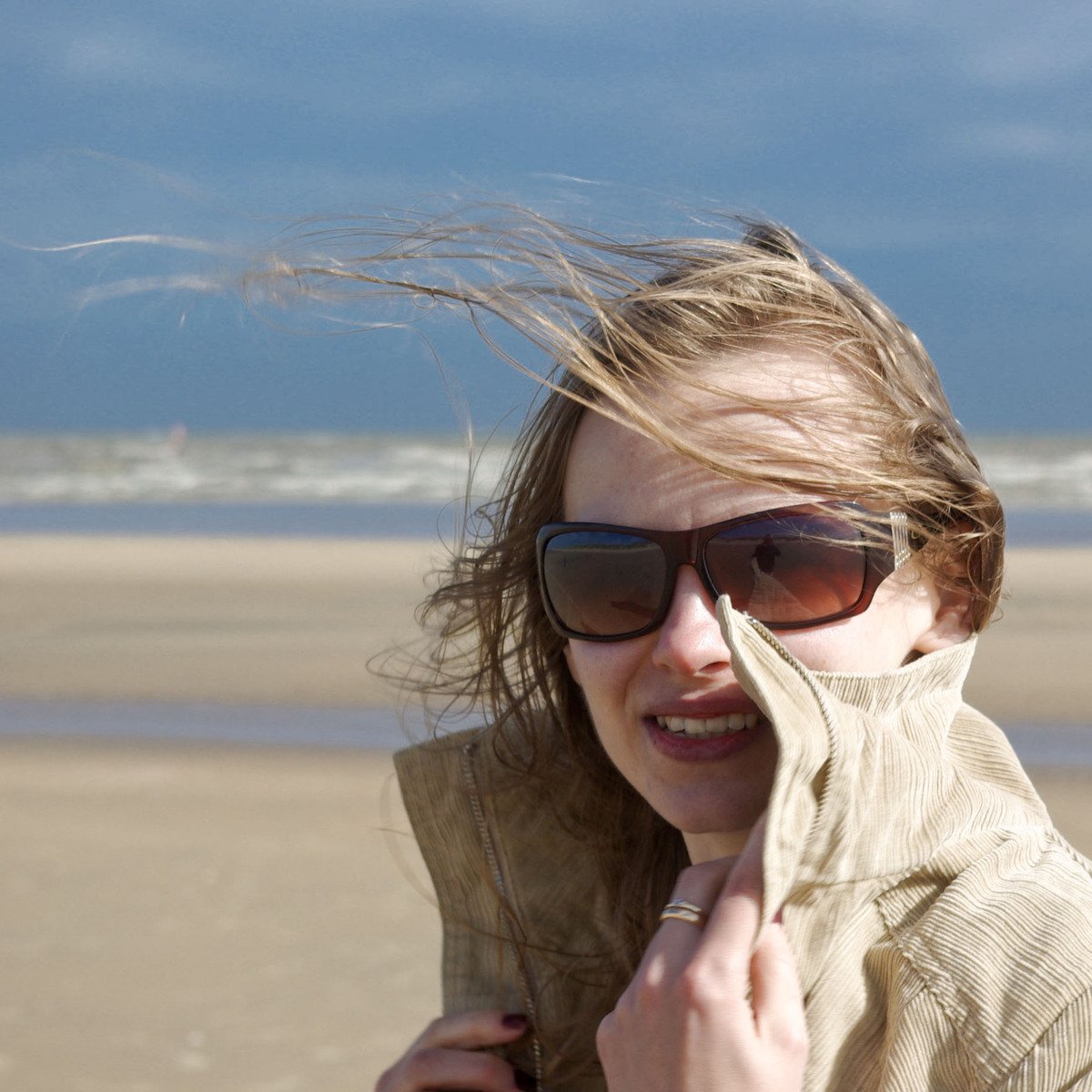 a girl is holding up her gloves to her face