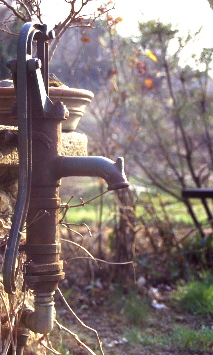 an old rusty water spigot with a hole in it