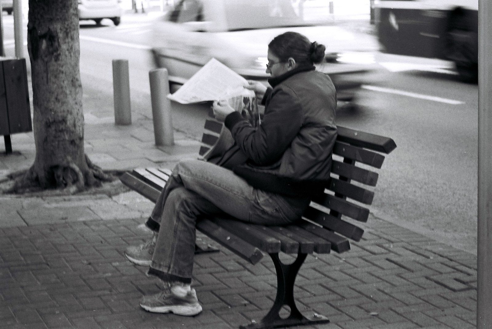 black and white po of a person sitting on bench reading