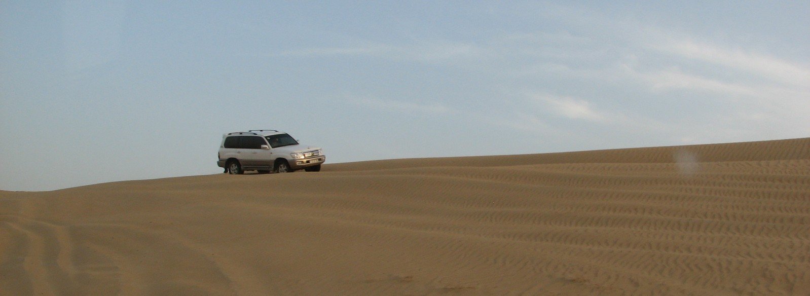 a car is driving in a desert like area