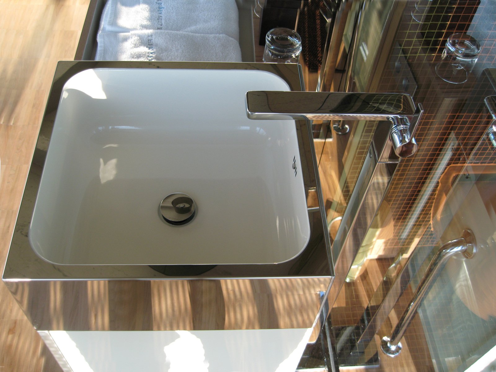 the modern bathroom sink is in stainless steel and has a soap dispenser in front of it