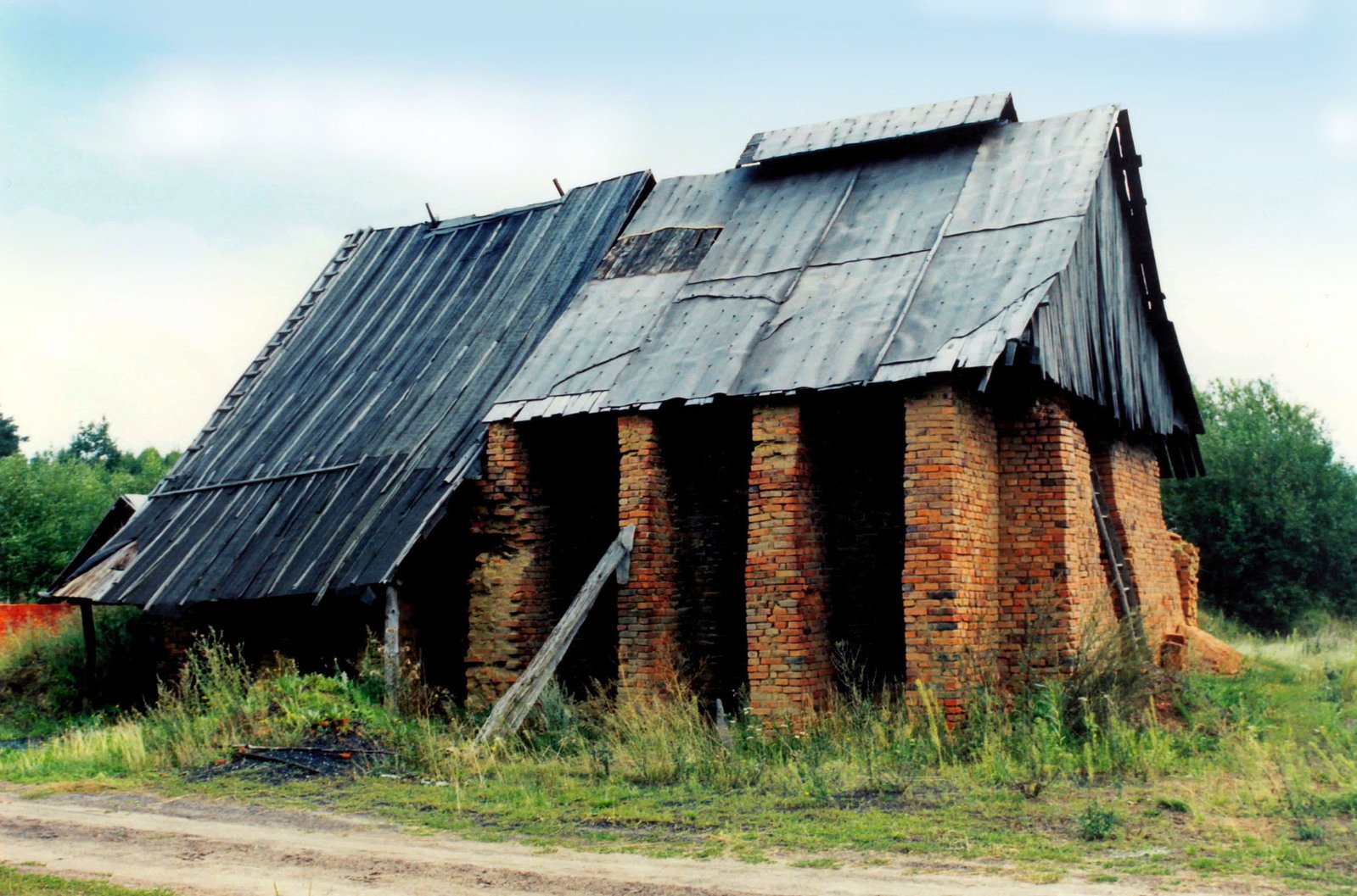 a very old, brick building with grass growing all around