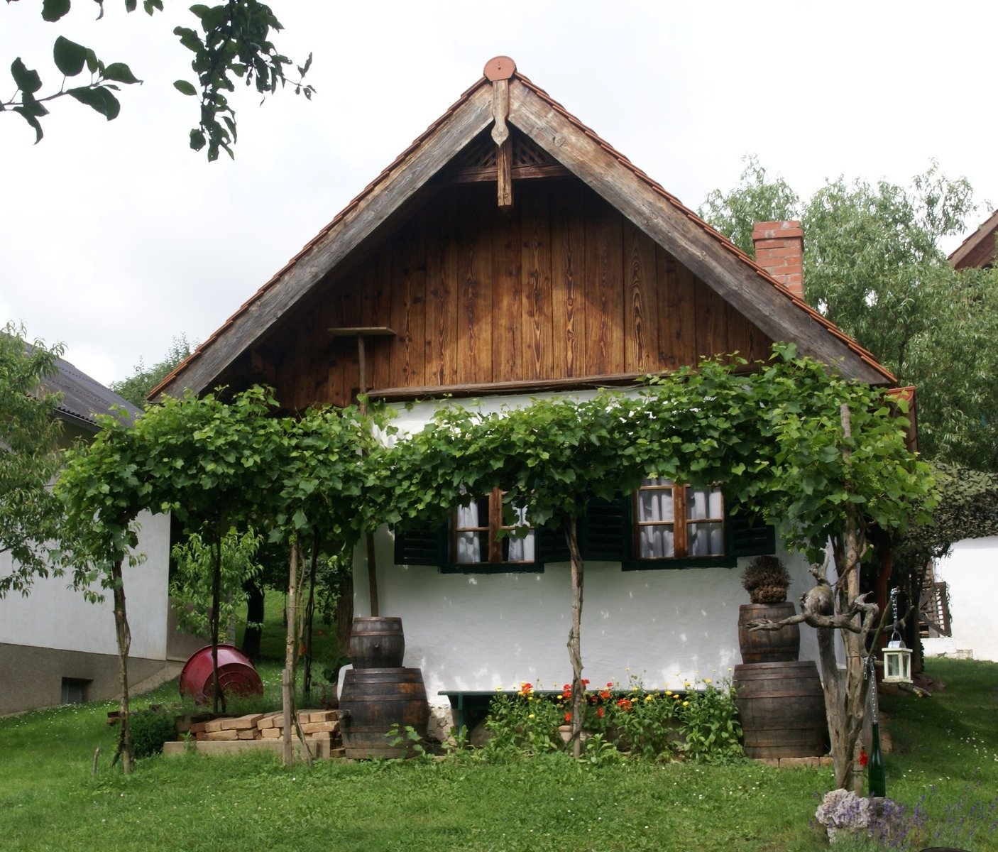 a small thatched cottage with lots of greenery on it