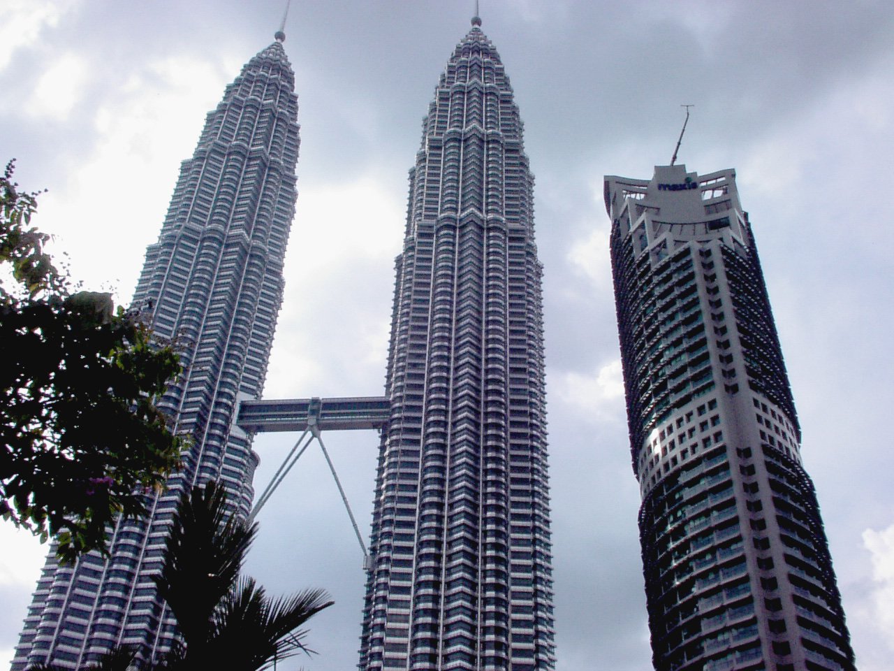 two tall towers are set against a cloudy sky