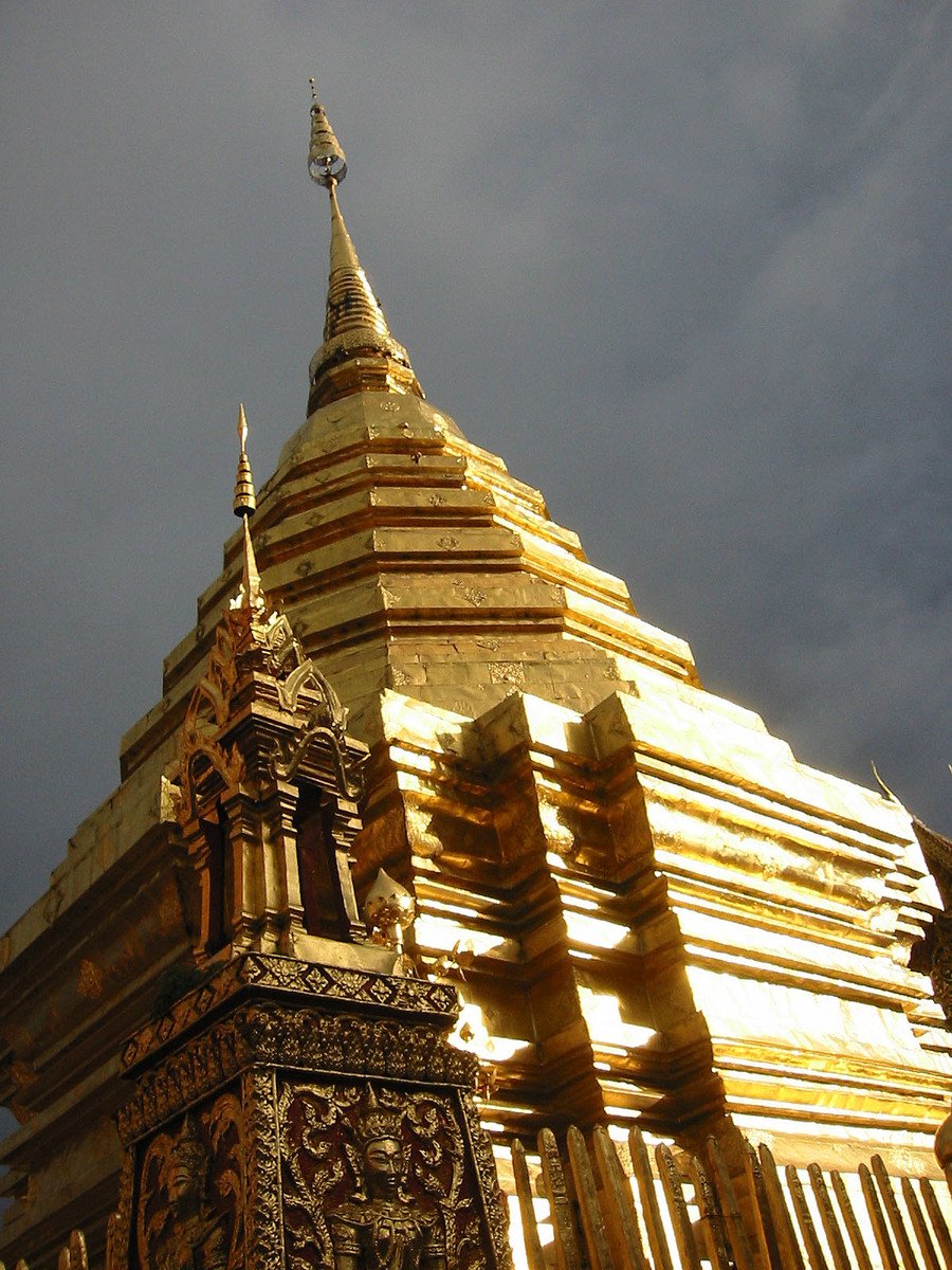 an ornate gold building against a black cloudy sky
