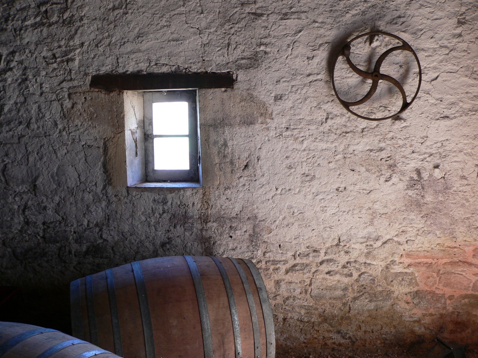 a barrel on the floor next to a window and a wooden barrel