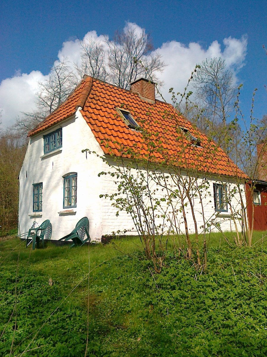 a small white and red home with a red roof