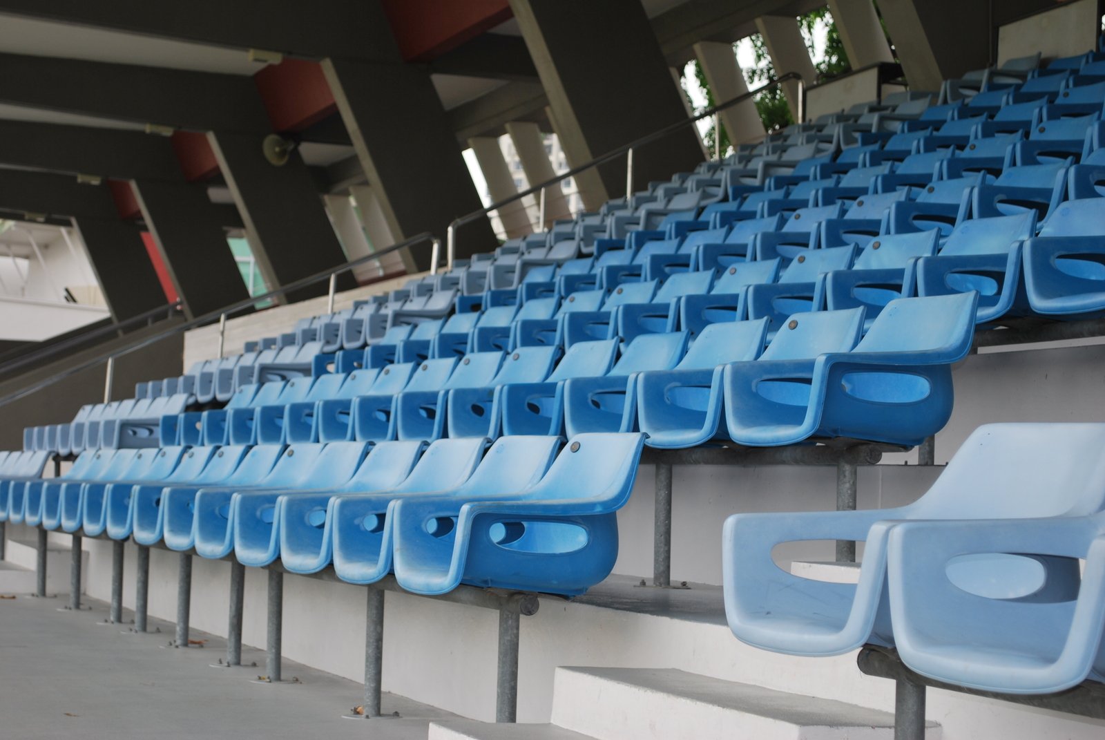 an empty row of blue chairs in the bleachers