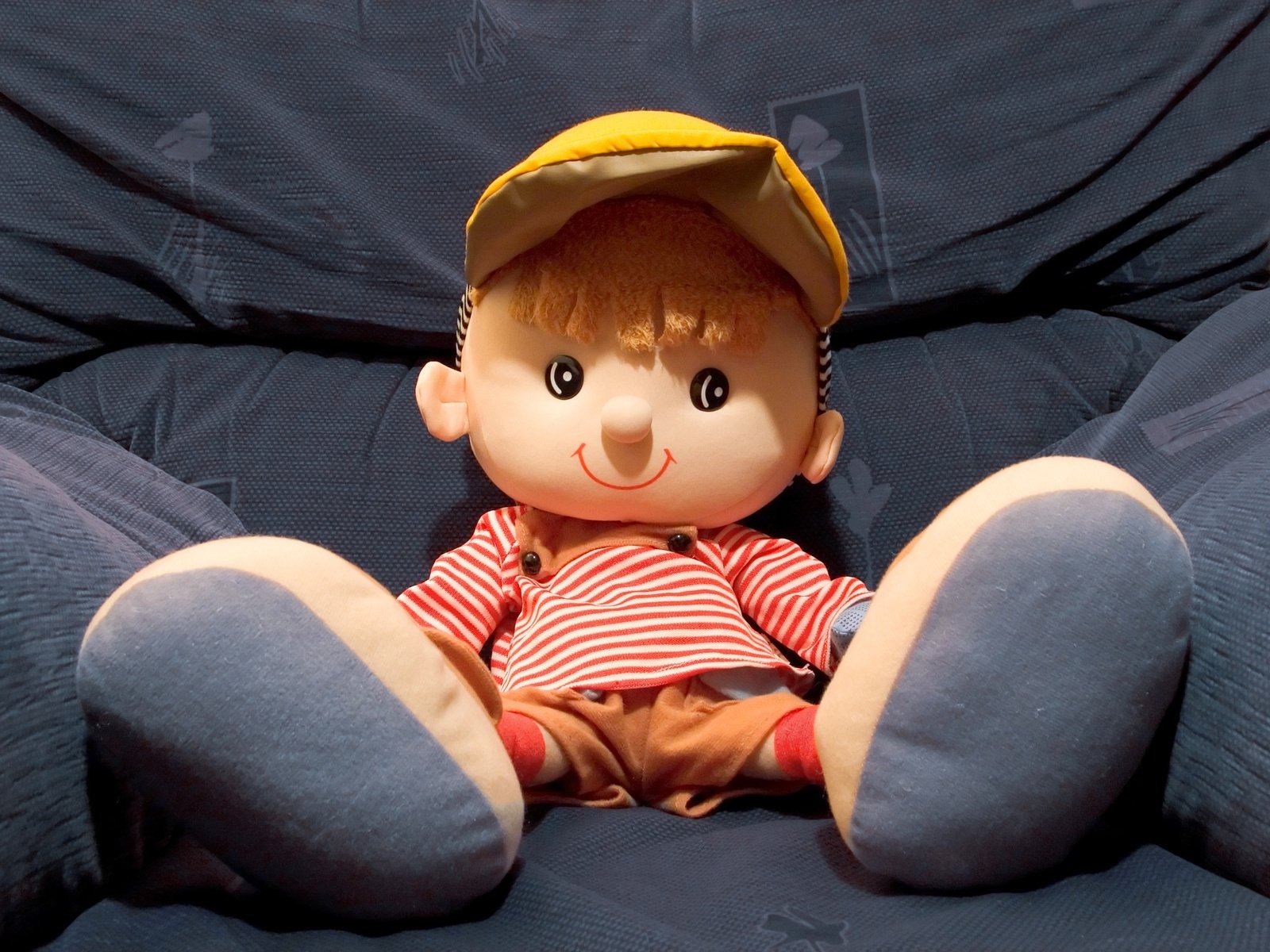 a stuffed doll wearing a striped shirt and hat