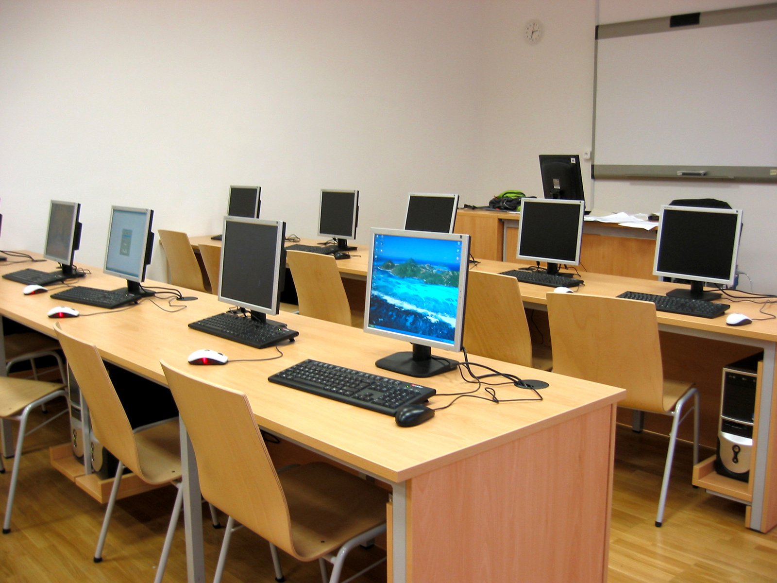 rows of computer monitors sit on each side of a desk