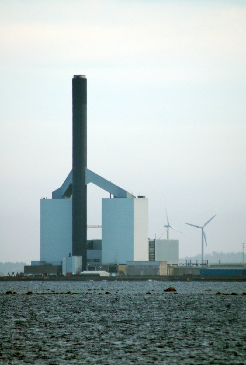 a power station is near some water and wind mills