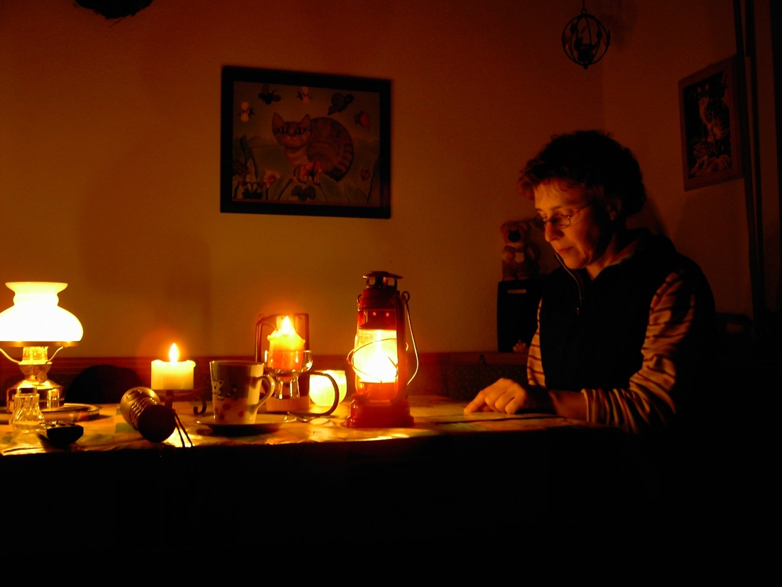 a man sits at a desk with various lit candles