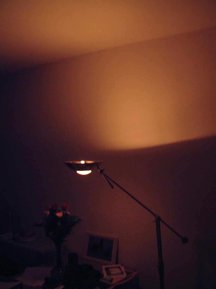 a lamp is shining on the wall in a dimly lit room
