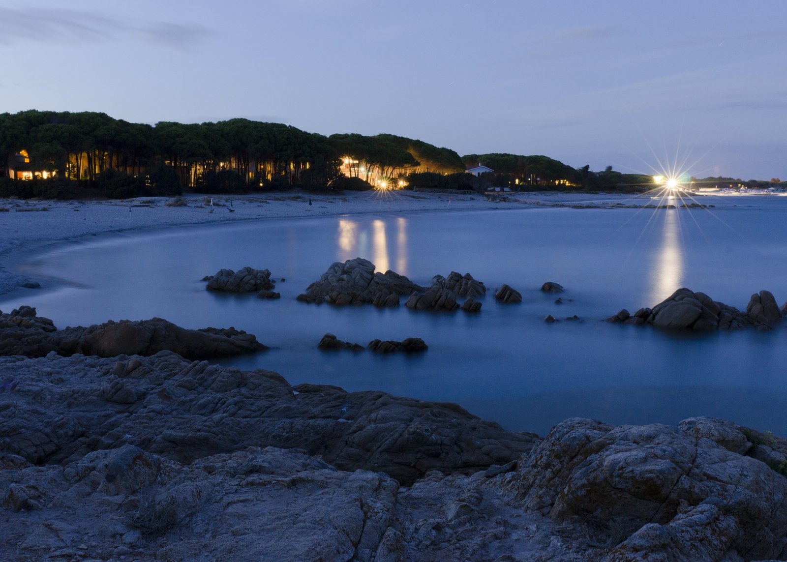 there are three boats in the water near some rocks