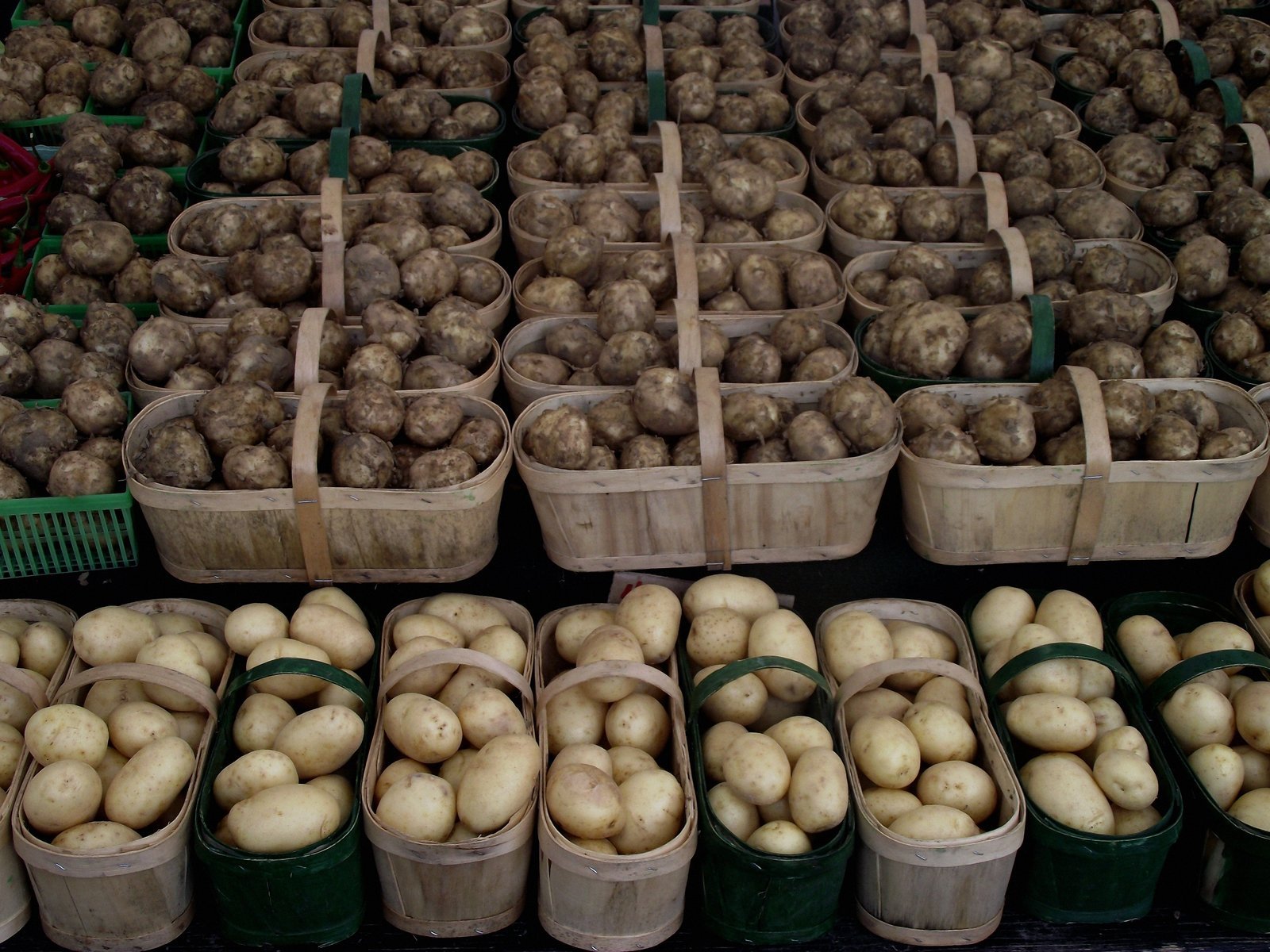 baskets of potatoes and other produce at a farmer's market