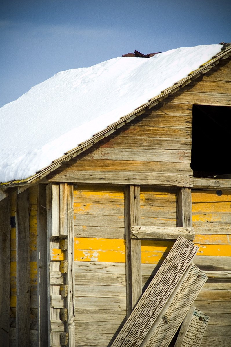 a snow capped top on top of a wooden building