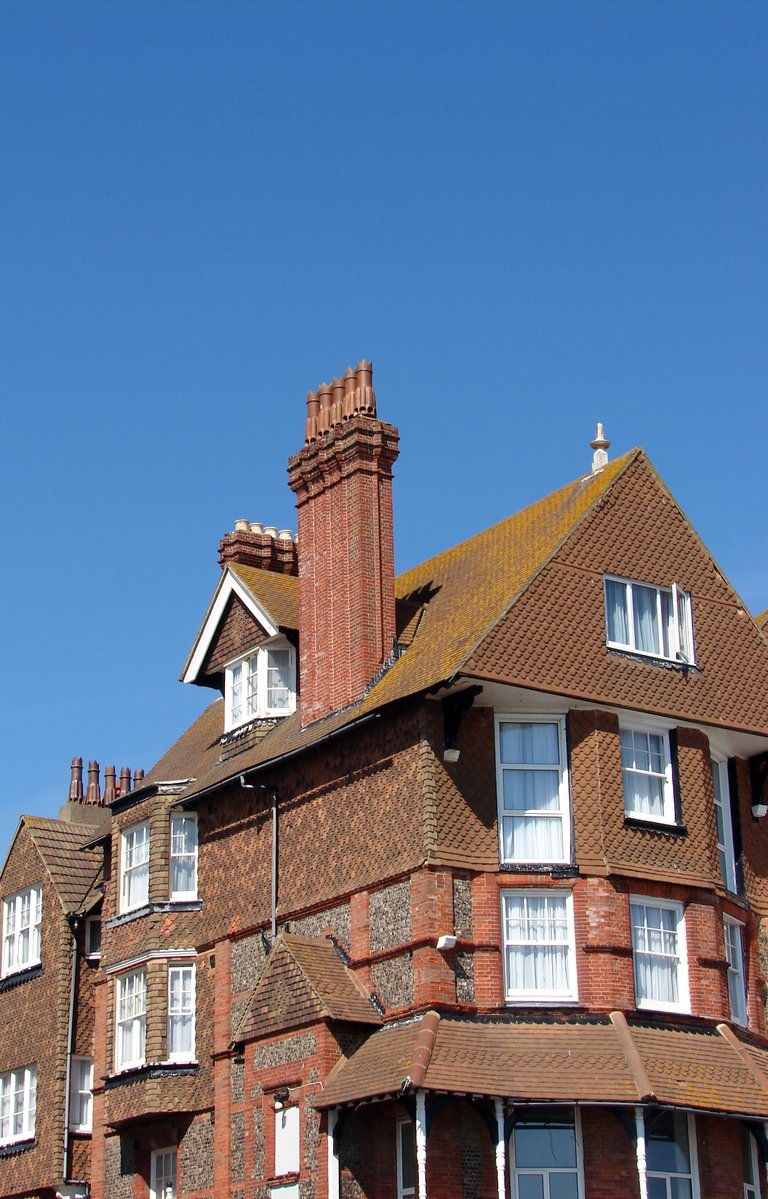 a large brick building with windows and chimneys