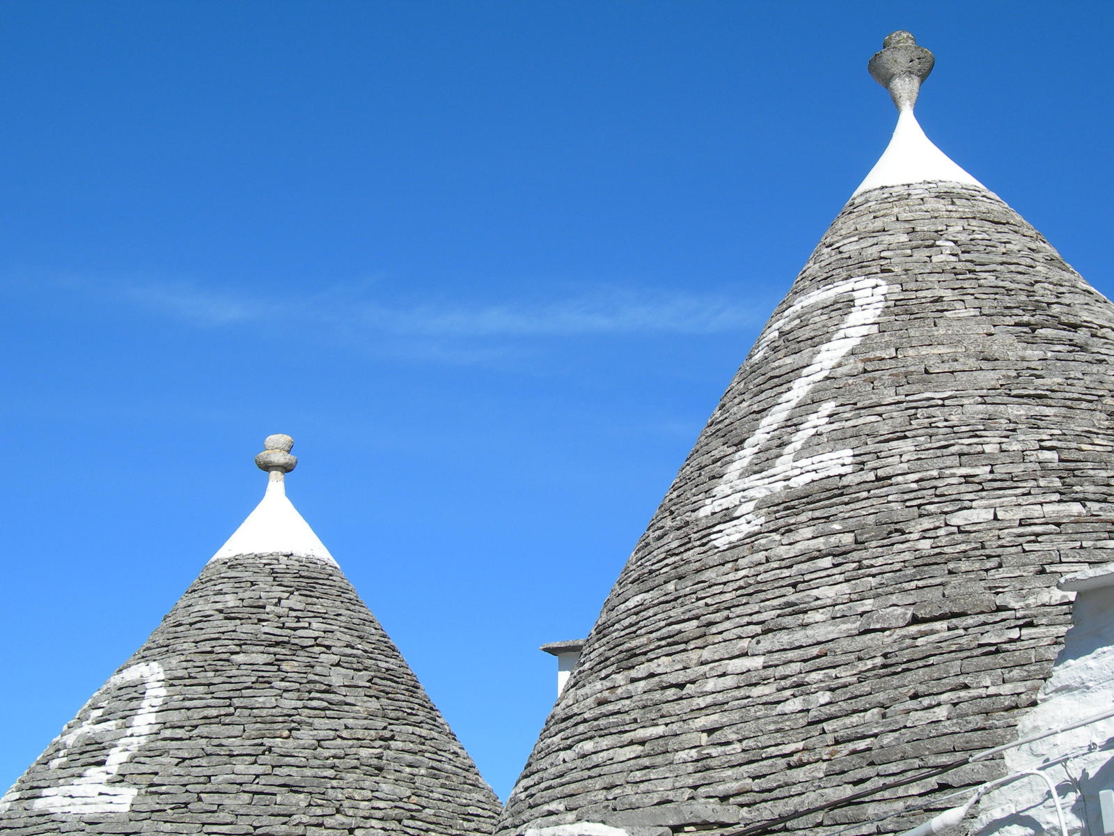 two pointed buildings with statues on top of it