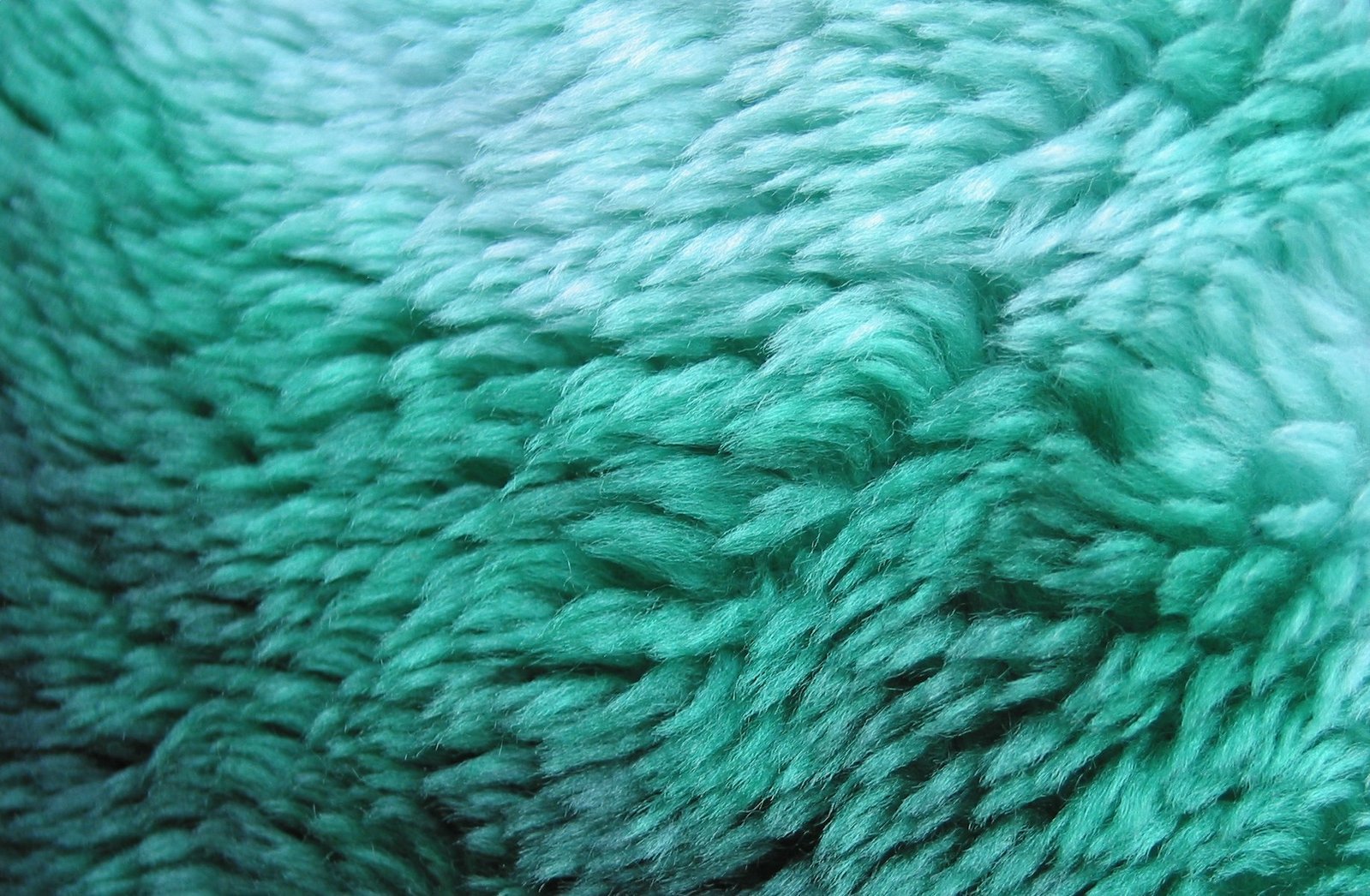 very fuzzy and soft teal green material in full view